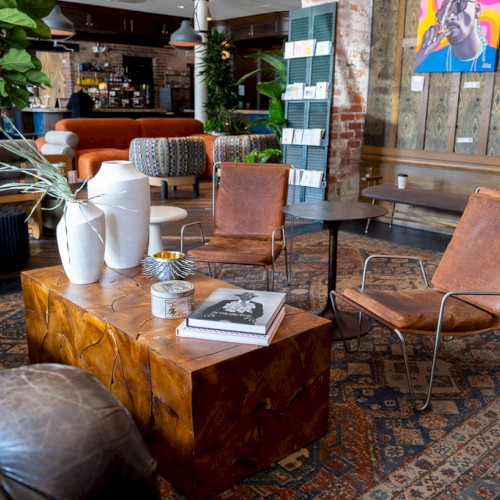 Cozy interior with eclectic furniture, rugs, plants, and art on the wall.