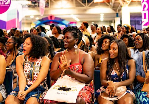 A group of attentive people sitting at an event, possibly a conference or seminar.