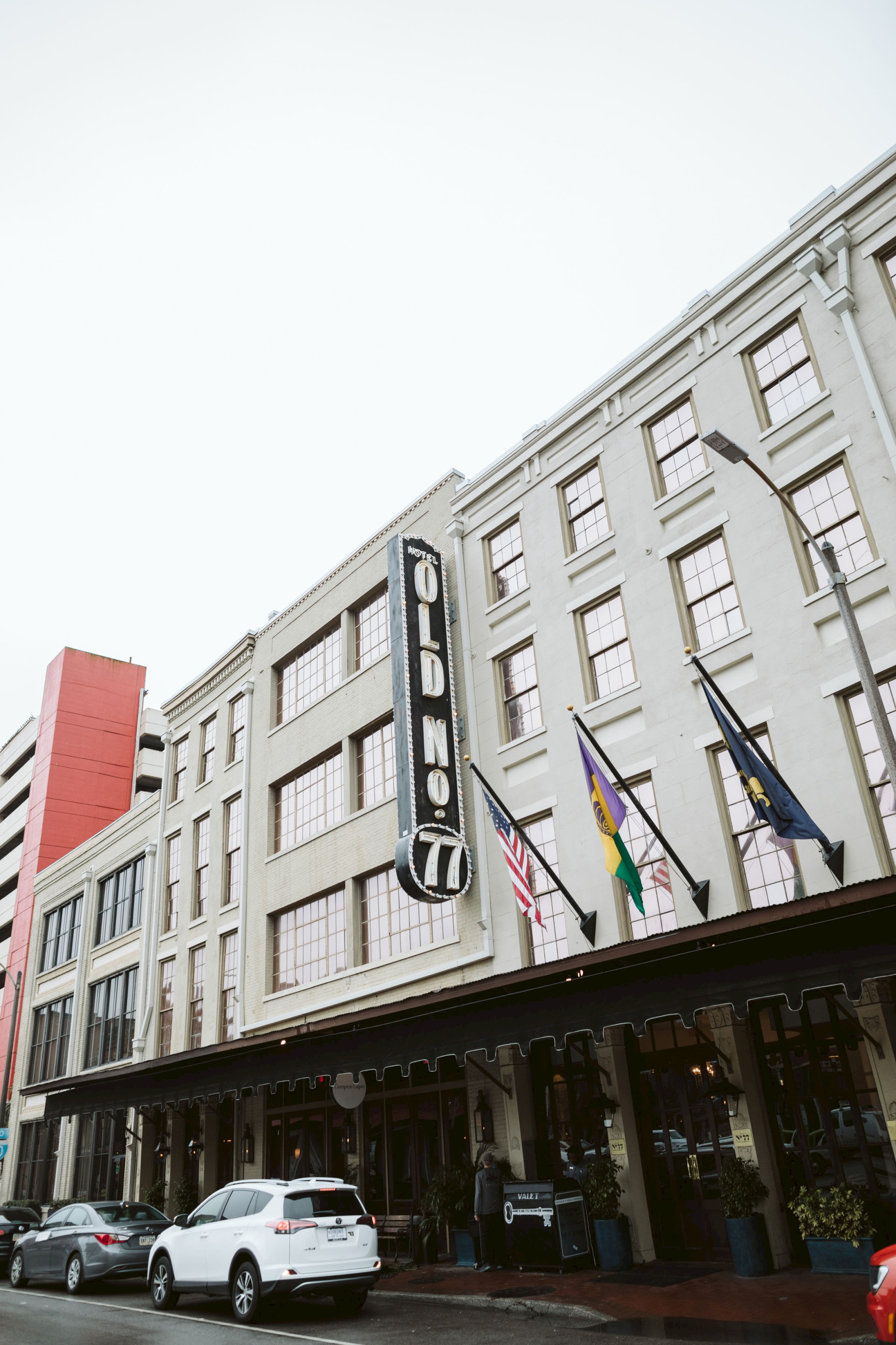 The image shows a multi-story building with a large vertical sign that reads 