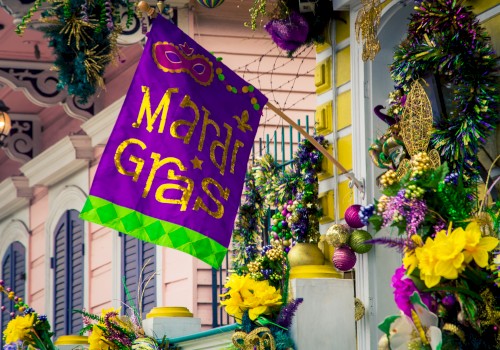 The image shows a festive Mardi Gras-themed display with a purple flag and decorations in yellow, gold, and green on a building facade.