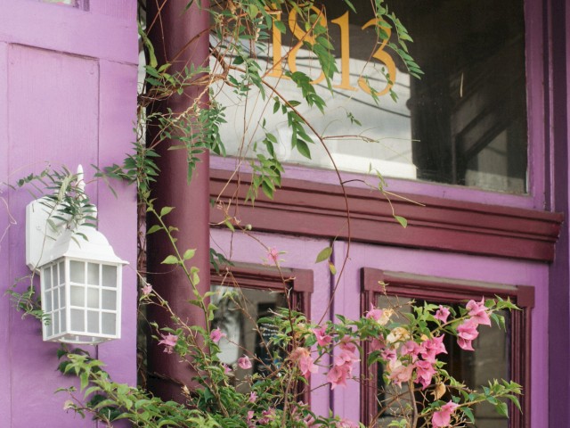 A purple building facade with a window displaying 
