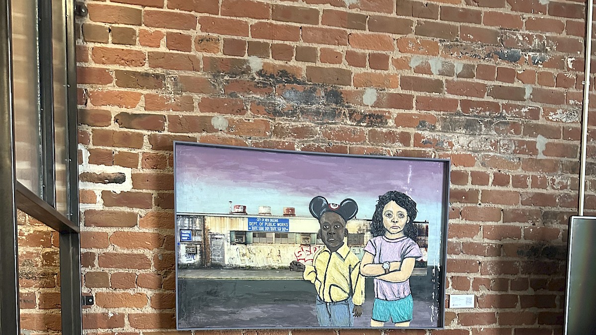 A mural of two children, one with mouse ears and a yellow jacket, standing in front of a brick building with a 